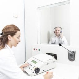 Patient receiving a hearing test in a booth