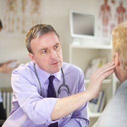 senior patient at the doctor's office gets her ears checked