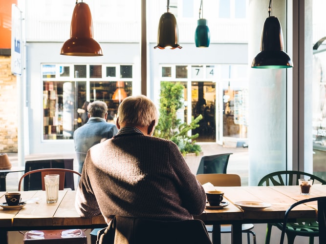 How Bad Is Untreated Hearing Loss for Your Brain? Man sitting inside of a coffee shop.