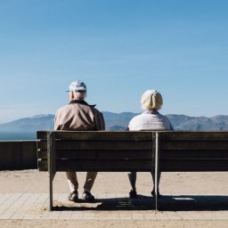 A couple sitting at a bench.