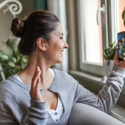 Woman with a hearing aid using a smartphone.