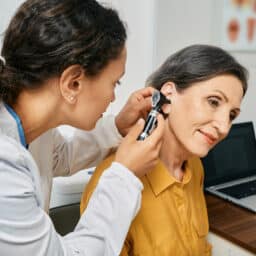 Woman getting her ears examined by a medical professional.