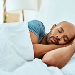 Young man sleeping peacefully in his bed.