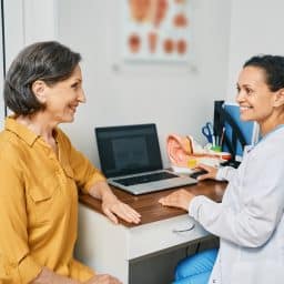 Audiologist consulting with a senior female patient about hearing loss.