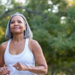 Senior woman jogging in public park.