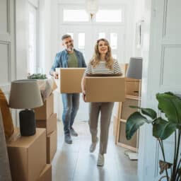 Mature couple moves in to their new home, unpacking boxes and enjoying the time together.