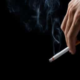 Close up of a man holding a cigarette