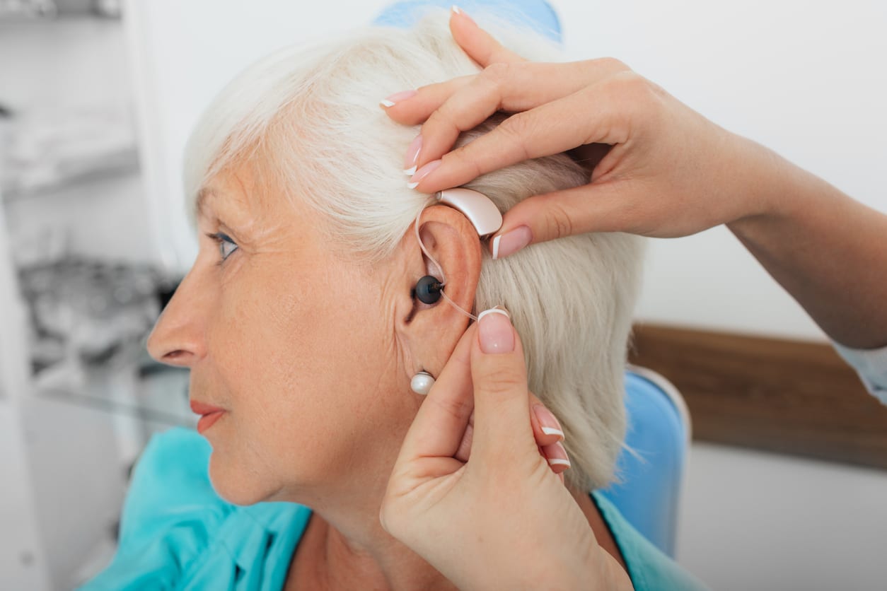 Senior woman getting a new hearing aid.