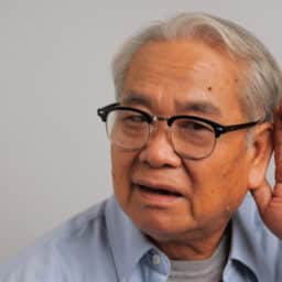 Man holds hand behind ear to hear