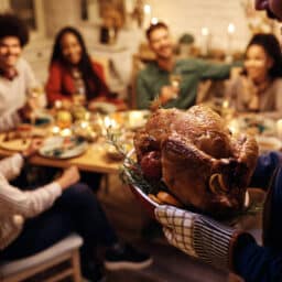 Happy, noisy family getting ready to eat turkey on Thanksgiving.