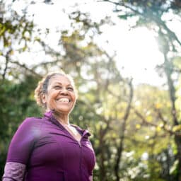 Happy, confident woman enjoying a hike in the woods.