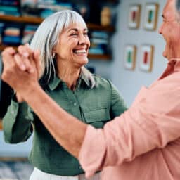 Happy couple dancing in the living room.