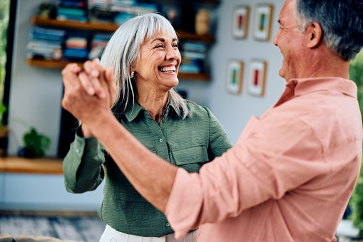 Happy couple dancing in the living room.