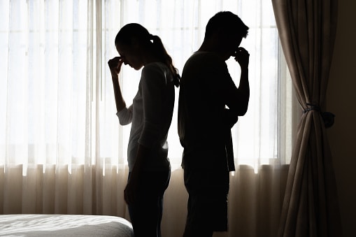 Silhouette of a couple feeling frustrated and remorseful after a disagreement. Communication is the bedrock of any relationship.