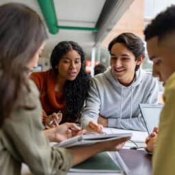 Happy group of students studying together at the library