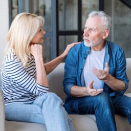 Mature husband shares his worries with wife while she listens with understanding and support, showing love and care